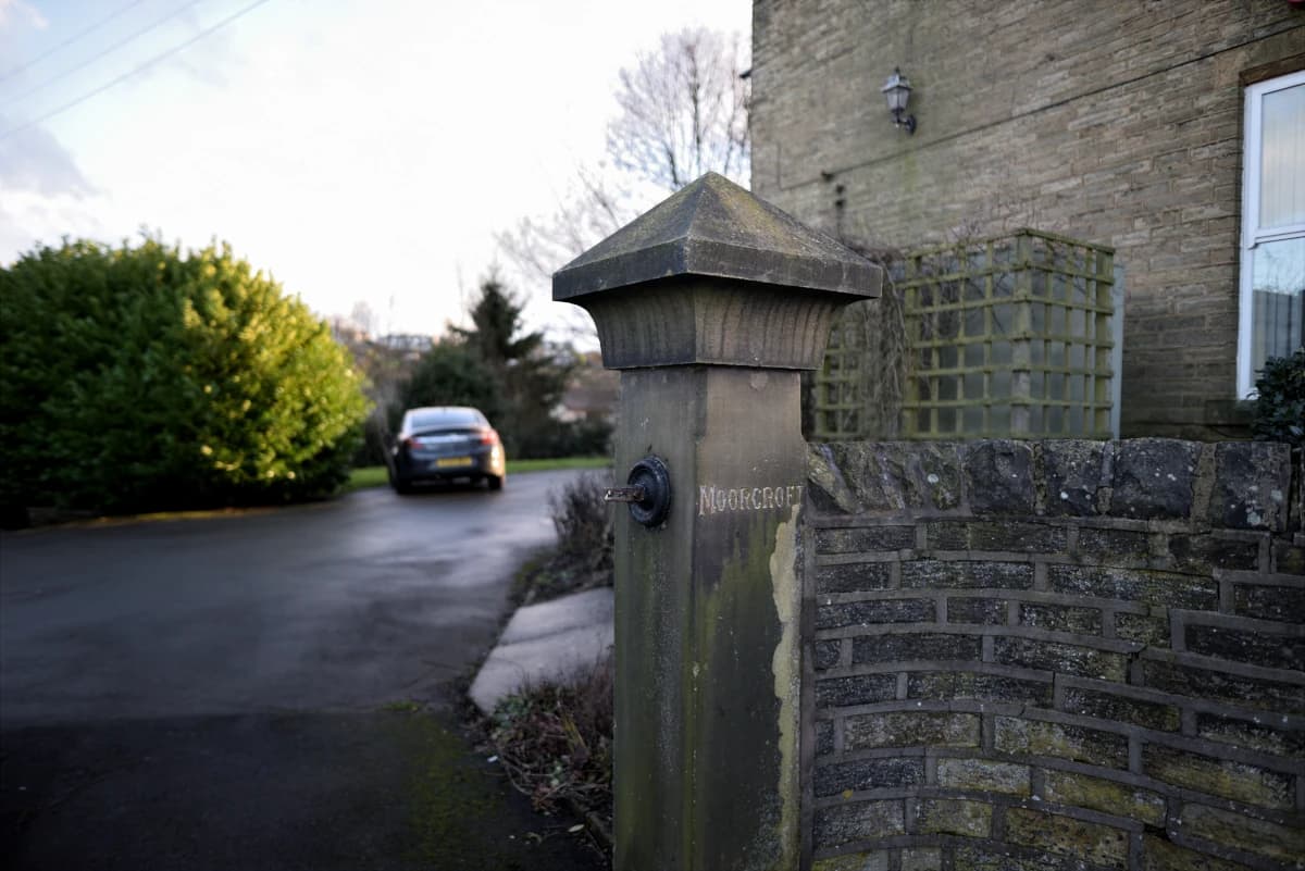 Close-up of the stone gatepost with MOORCROFT engraved on it, marking the studio driveway entrance