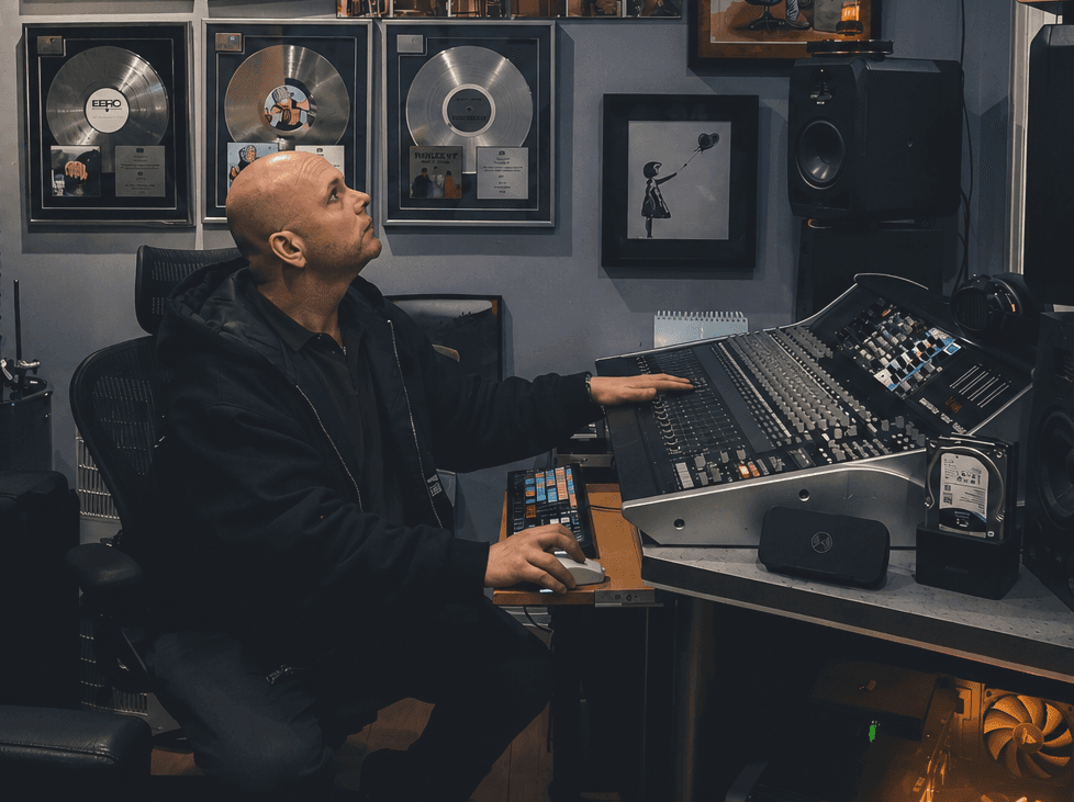 Tom Fox at Moorcroft Studios mixing console with platinum records on the wall