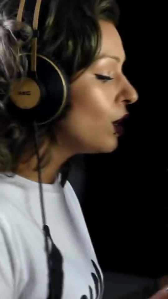 Vocalist wearing studio headphones recording into a microphone at Moorcroft Studios